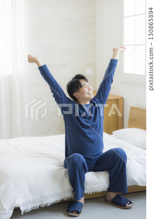 躺在床上伸展的男人 130865894