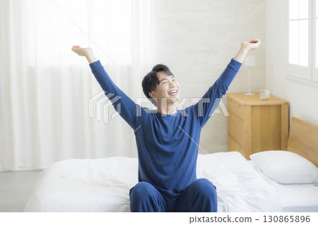Man stretching in bed 130865896