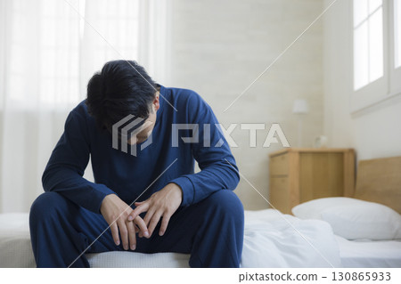 Tired man in bedroom 130865933