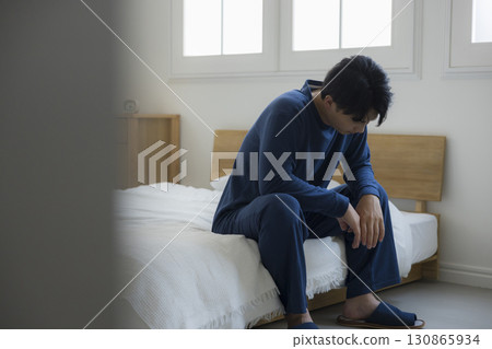 Tired man in bedroom Tired man in bedroom 130865934