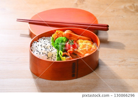 色彩繽紛的便當圖片。豬肉生煎、維也納香腸、玉子燒（蛋捲）、胡蘿蔔絲和青花菜。 130866296