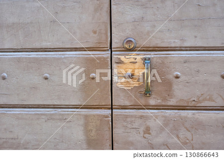 Weathered Wooden Door Shows Signs of Age and Wear in a Rustic Location Under Natural Light Weathered Wooden Door Shows Signs of Age and Wear in a Rustic Location Under Natural Light 130866643
