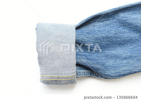 roll up sleeve of blue denim shirt texture isolated on white background, jean fashion style 130866684