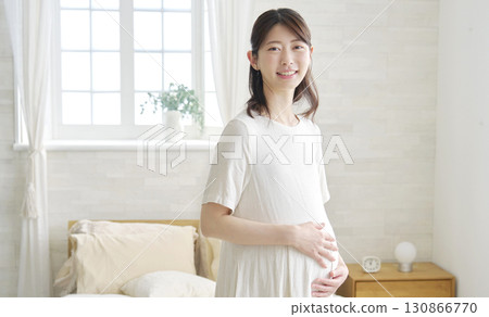 Pregnant woman portrait at home looking at camera Pregnant woman portrait at home looking at camera 130866770