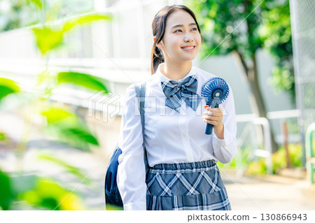 High school girl using a portable fan 130866943