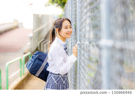 School girls wearing uniforms in front of the school building 130866948