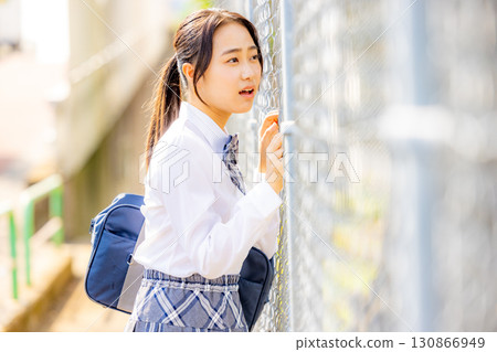 School girls wearing uniforms in front of the school building School girls wearing uniforms in front of the school building 130866949