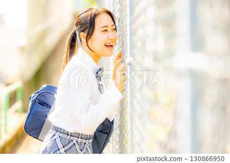 School girls wearing uniforms in front of the school building School girls wearing uniforms in front of the school building 130866950