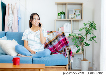 一個女人在客廳裡看著她的智能手機 130866984