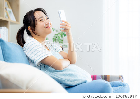 A woman looking at her smartphone in the living room A woman looking at her smartphone in the living room 130866987