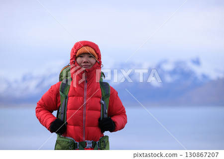 Backpacking woman hiking on high altitude mountain top 130867207