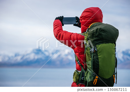 Backpacking woman hiking on high altitude mountain top 130867211
