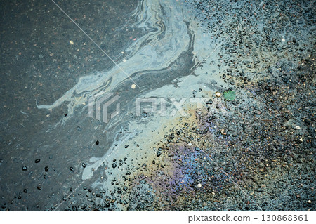 Colorful fuel spill generating intriguing shapes on the damp pavement after the rain. Colorful fuel spill generating intriguing shapes on the damp pavement after the rain. 130868361