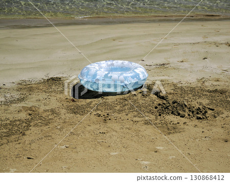 Swim ring and sandy beach 130868412