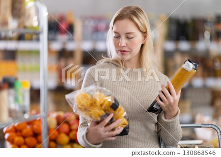 Young woman choosing pasta in grocery store Young woman choosing pasta in grocery store 130868546