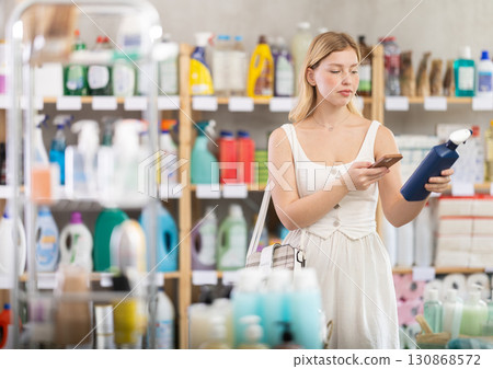 Girl scanning cleaning spray for mobile payment in household store Girl scanning cleaning spray for mobile payment in household store 130868572