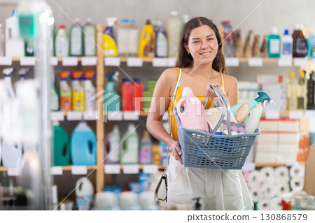 Young woman chooses household chemicals in store Young woman chooses household chemicals in store 130868579