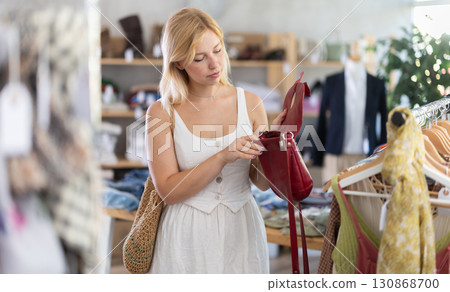 Fashionista girl near showcase examine goods, buying handbag 130868700