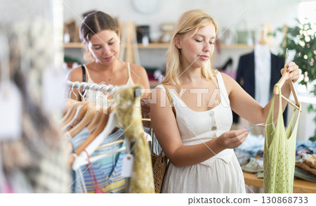 Two young women choosing top in store Two young women choosing top in store 130868733