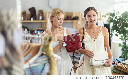 Two women choose fashionable handbags in the store 130868761