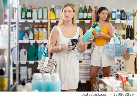 Young woman chooses cleaning spray in store 130868889