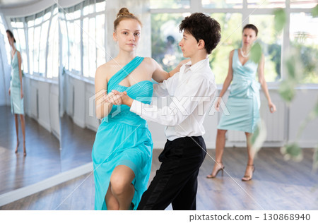 Teenage boy and girl performing waltz in pair during dance lesson 130868940