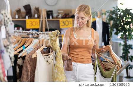 Fashionista girl near showcase examine goods, buying something clothing for summer. 130868955