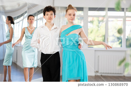 Dance teacher teaches a girl and a boy couples ballroom dancing 130868970