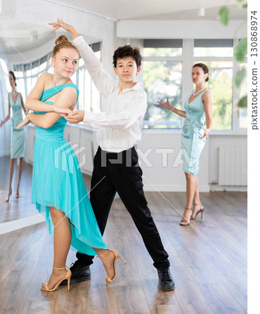 Motivated adolescent ballroom dancers practicing dance moves in studio 130868974