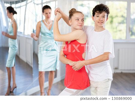 Passionate teen dancers, girl and boy practicing ballroom dancing in studio 130869000