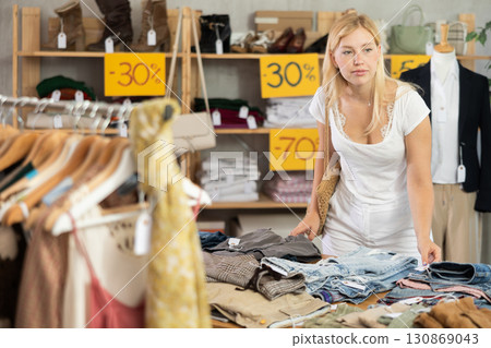 Young woman choosing jeans in clothing store Young woman choosing jeans in clothing store 130869043