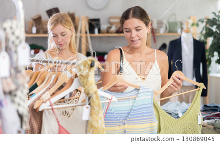 Fashionista girls friends near showcase examine goods, buying something clothing for summer. 130869045