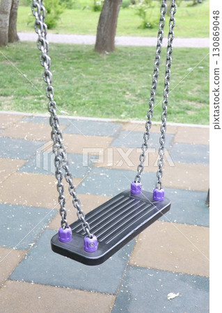 Enjoying a Playground Swing for Children in a Beautiful Park Setting with Family and Friends 130869048