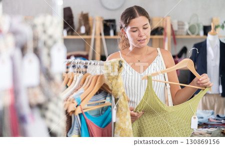 Fashionista girl near showcase examine goods, buying something clothing for summer. 130869156