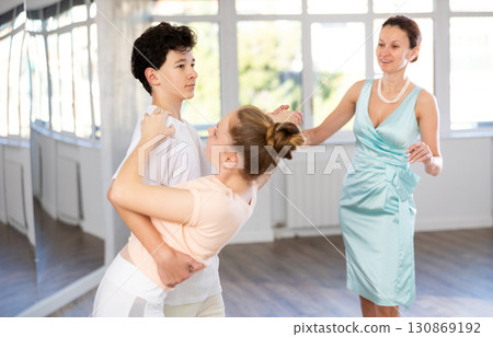 Passionate teen dancers, girl and boy practicing ballroom dancing in studio Passionate teen dancers, girl and boy practicing ballroom dancing in studio 130869192