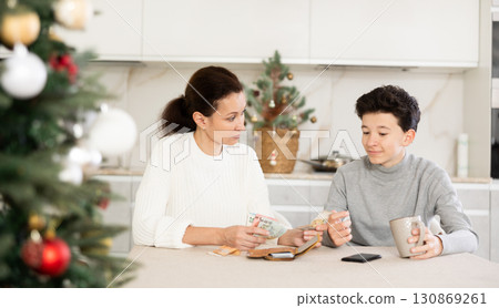 Son takes pocket money from mom before celebrating Christmas in room Son takes pocket money from mom before celebrating Christmas in room 130869261