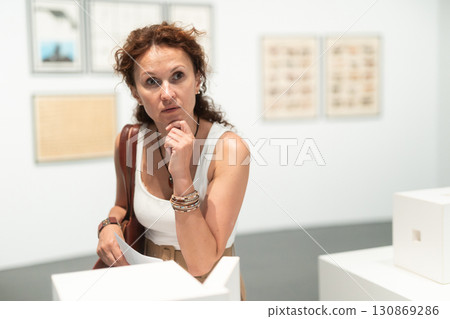 Middle-aged woman looking at building models in museum Middle-aged woman looking at building models in museum 130869286