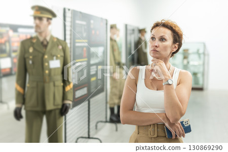 Middle-aged woman looking at exhibits in military museum 130869290