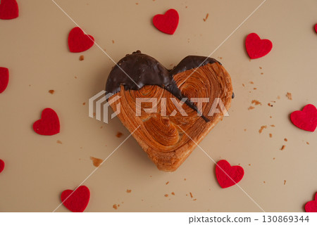 Love concept Valentine's day Heart shaped dark chocolate croissant on beige background with copy space. Puff pastry new trendy sweet dessert bakery. Creamy dough Love concept Valentine's day Heart shaped dark chocolate croissant on beige background with copy space. Puff pastry new trendy sweet dessert bakery. Creamy dough 130869344