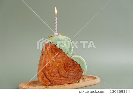Festive holiday candle birthday anniversary celebration Heart shaped pistachio croissant on green background with copy space. Puff pastry trendy sweet dessert bakery. Creamy dough experiment Festive holiday candle birthday anniversary celebration Heart shaped pistachio croissant on green background with copy space. Puff pastry trendy sweet dessert bakery. Creamy dough experiment 130869354
