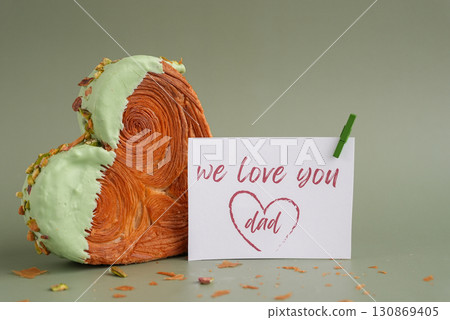 WE LOVE YOU DAD words greeting card Father's Day Delicious fresh croissant topped with Matcha Green Tea flavor Ganache. Creation unique heart shape bakery. Puff pastry holiday love gift present idea 130869405