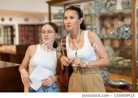 Woman and teenage girl looking at exhibition of tableware 130869418
