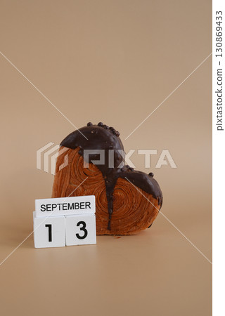 Chocolate day 13 September wooden calendar cubes wishes greeting holiday card Heartshaped pastry croissant treat topped with colorful frosting galore. Food experimentation viral dessert baking trend 130869433
