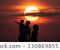 (AI-generated) Family image: A large sunset and the silhouette of a parent and child standing together 130869855