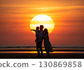 (AI-generated) Family image: A large sunset and the silhouette of a parent and child standing together 130869858
