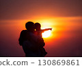 (AI-generated) Family image: Silhouette of a young parent and child standing together in the sunset 130869861