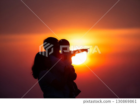 (AI-generated) Family image: Silhouette of a young parent and child standing together in the sunset (AI-generated) Family image: Silhouette of a young parent and child standing together in the sunset 130869861