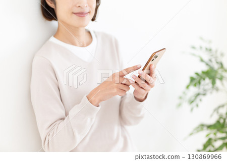 A casual middle-aged female business woman looking at her smartphone 130869966