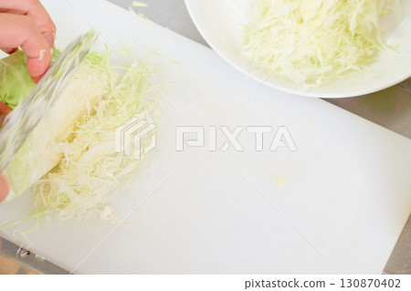 A close-up of a man's hands shredding cabbage for a salad. A series of photographs of a man preparing a meal. A close-up of a man's hands shredding cabbage for a salad. A series of photographs of a man preparing a meal. 130870402