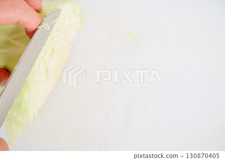 A close-up of a man's hands shredding cabbage for a salad. A series of photographs of a man preparing a meal. A close-up of a man's hands shredding cabbage for a salad. A series of photographs of a man preparing a meal. 130870405